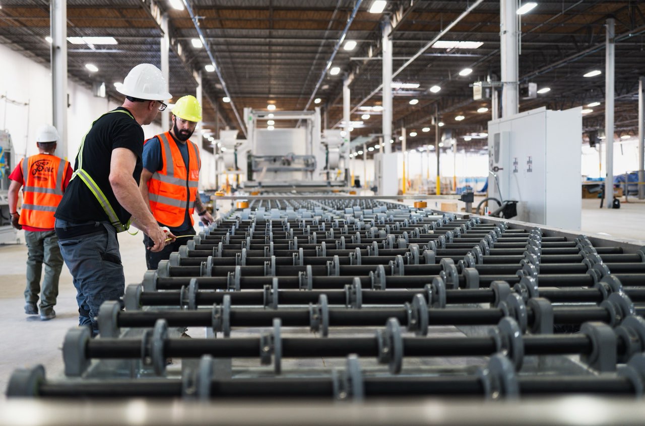 Workers inspecting conveyor roller systems